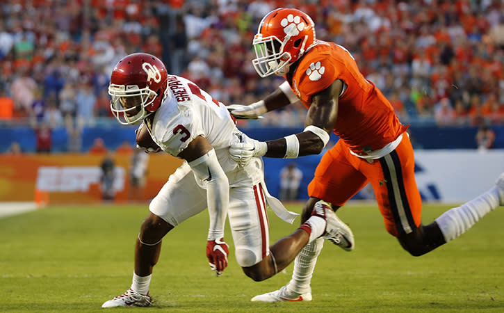 Oklahoma Sooners wide receiver Sterling Shepard tries to pull away from former Clemson Tigers safety Jayron Kearse , Minnesota Vikings' seventh round draft pick.