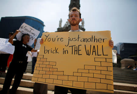 A demonstrator holds a placard during a protest against the visit of U.S. Republican presidential candidate Donald Trump, at the Angel of Independence monument in Mexico City, Mexico, August 31, 2016. REUTERS/Tomas Bravo