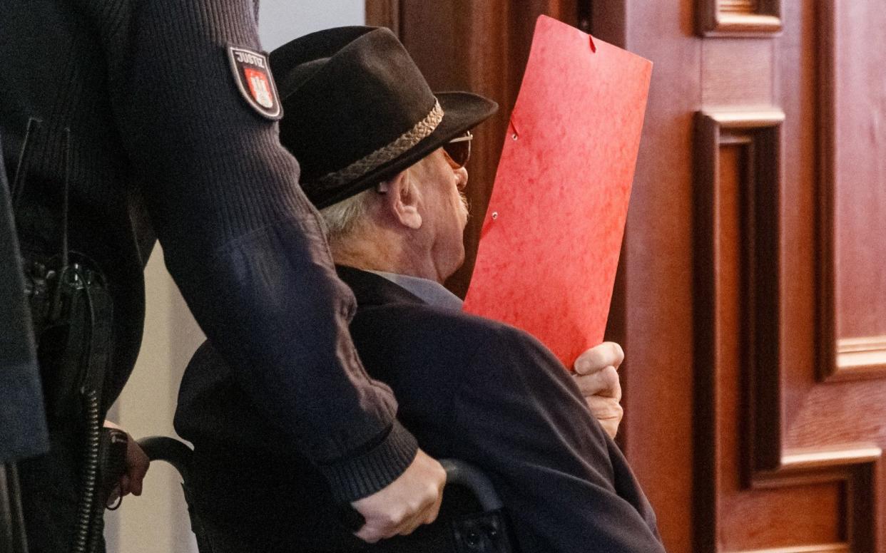 Former SS guard Bruno Dey covers his face as he arrives at the courtroom in Hamburg, October 2019