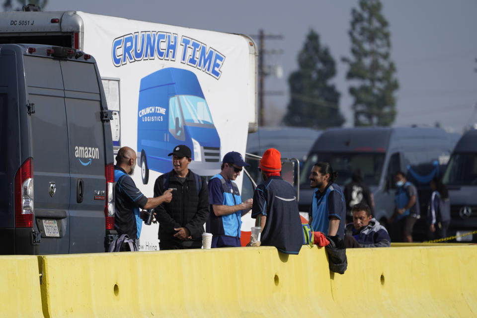 Amazon drivers wait next to a Crunch Time station as their logistics systems is offline at the Amazon Delivery Station in Rosemead, Calif., Tuesday, Dec. 7, 2021. Amazon Web Services is suffering a major outage. The company provides cloud computing services to individuals, universities, governments and companies, including The Associated Press. (AP Photo/Damian Dovarganes)