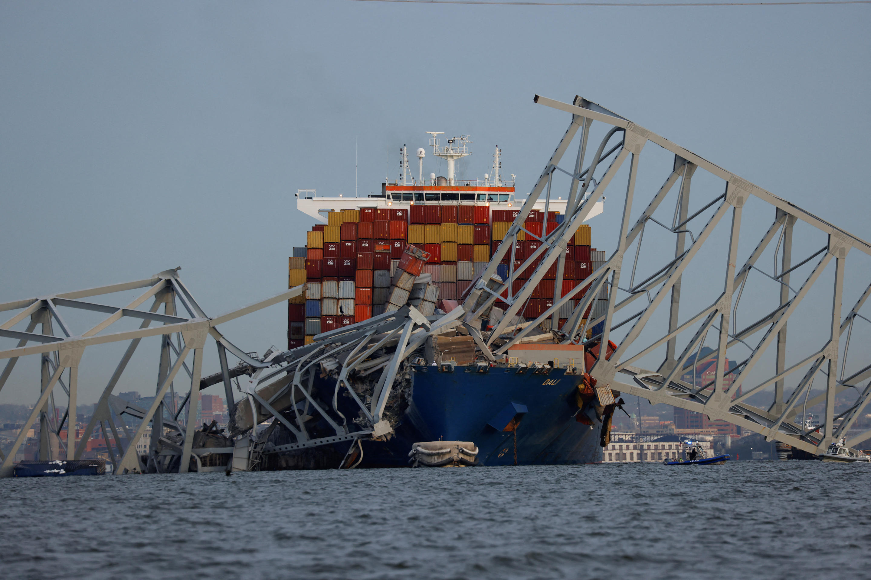 Dali cargo vessel amid bent sections of destroyed bridge.