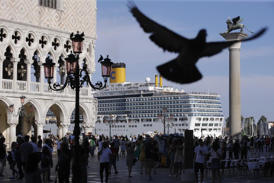 ARCHIVO - En esta foto de archivo del 2 de junio de 2019, un buque crucero pasa junto a la Plaza de San Marco, Venecia. Los científicos dicen que es necesario dejar de usar combustibles fósiles como máximo para 2050 para evitar que la temperatura global suba más de 1,5 grados Celsius. (AP Foto/Luca Bruno, File)