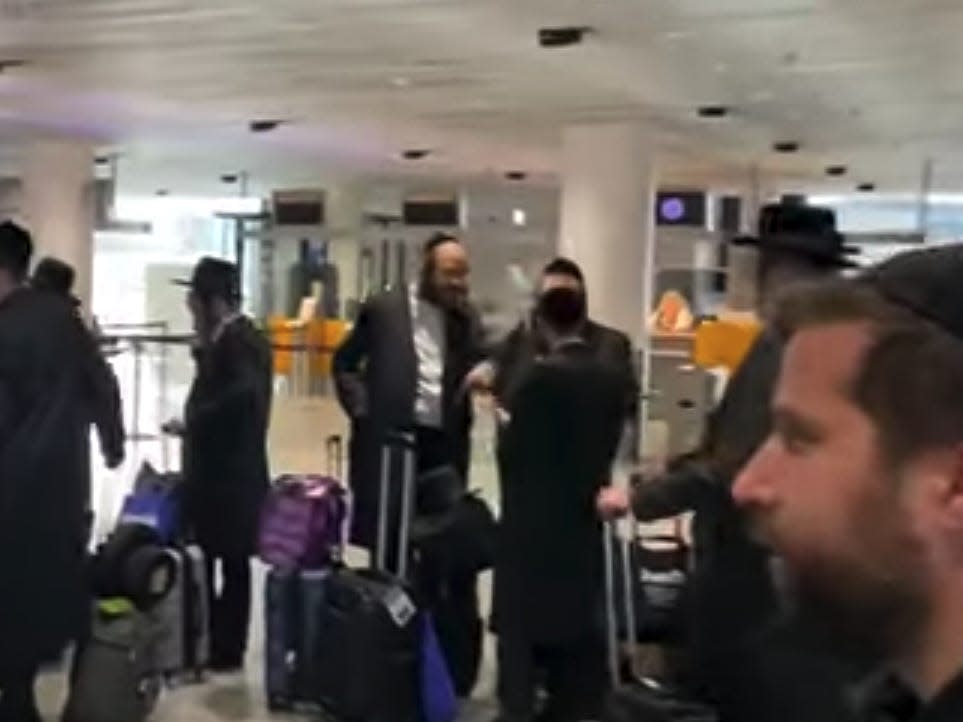Orthodox Jewish passengers wait in line after being barred from boarding a connecting Lufthansa flight to Budapest.