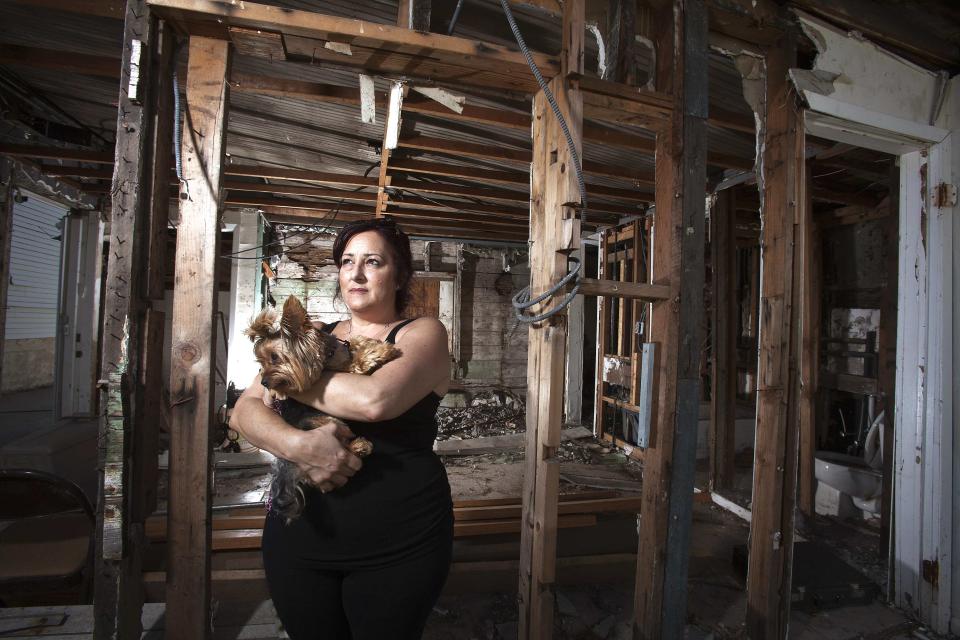 Christine Cina poses for a portrait in what is left of her house after Superstorm Sandy in the Staten Island borough of New York, September 20, 2013. A year after Superstorm Sandy wreaked havoc across the eastern United States, only a fraction of the aid money earmarked for recovery has been used, in what some claim is a painfully slow and opaque process. Picture taken September 20, 2013. To match story STORM-SANDY/MONEY REUTERS/Carlo Allegri (UNITED STATES - Tags: SOCIETY DISASTER BUSINESS PORTRAIT)