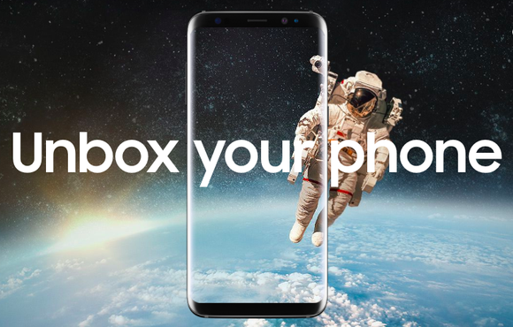 Unbox Your Phone is overlayed on a picture of the Samsung Galaxy S8 featuring a background of outerspace with an astronaut floating above Earth.