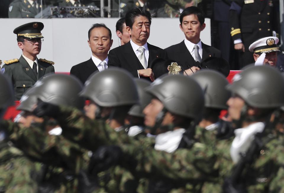 FILE - In this Oct. 23, 2016, file photo, Japanese Prime Minister Shinzo Abe, center, reviews members of Japan Self-Defense Forces during a parade of the Self-Defense Forces Day at Asaka Base in Asaka, north of Tokyo. Japan’s ruling party is expected to approve a change in party rules Sunday, March 5, 2017, that could pave the way for Abe to become the country’s longest-serving leader in the post-World War II era. (AP Photo/Eugene Hoshiko, File)