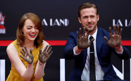 Actors Emma Stone and Ryan Gosling show their hands after placing them in cement during a ceremony in the forecourt of the TCL Chinese theatre in Hollywood, California U.S., December 7, 2016. REUTERS/Mario Anzuoni