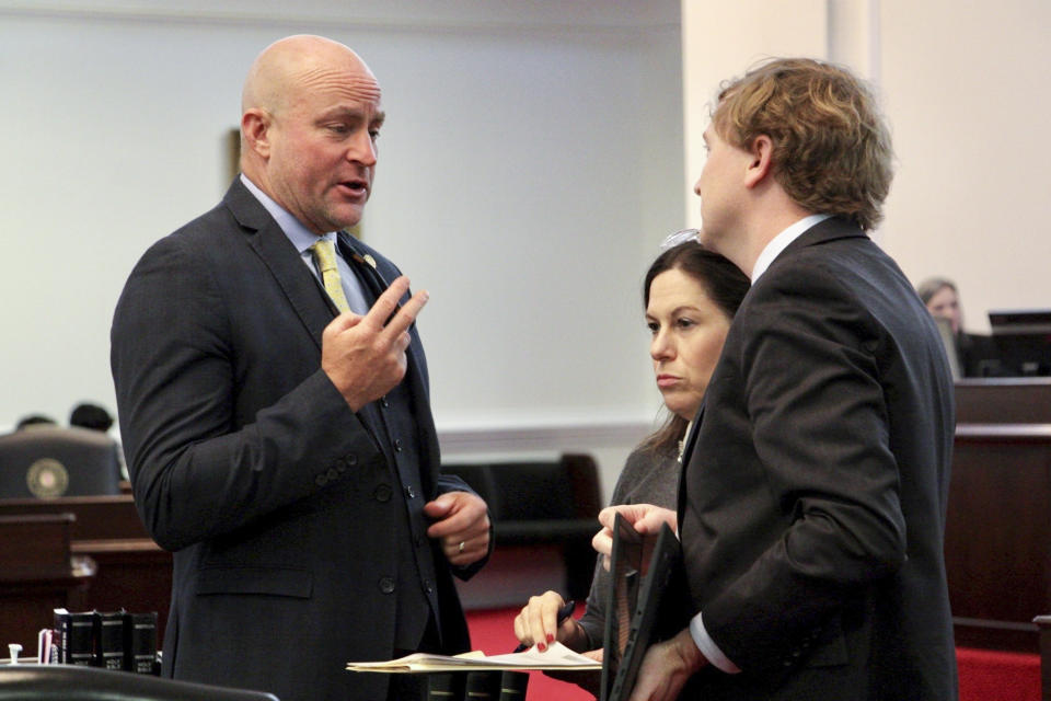 North Carolina state Sen. Danny Britt, left, a Robeson County Republican, speaks with legislative staff Thursday, May 4, 2023, on the Senate floor in Raleigh, N.C., before the chamber votes on an abortion bill. (AP Photo/Hannah Schoenbaum)