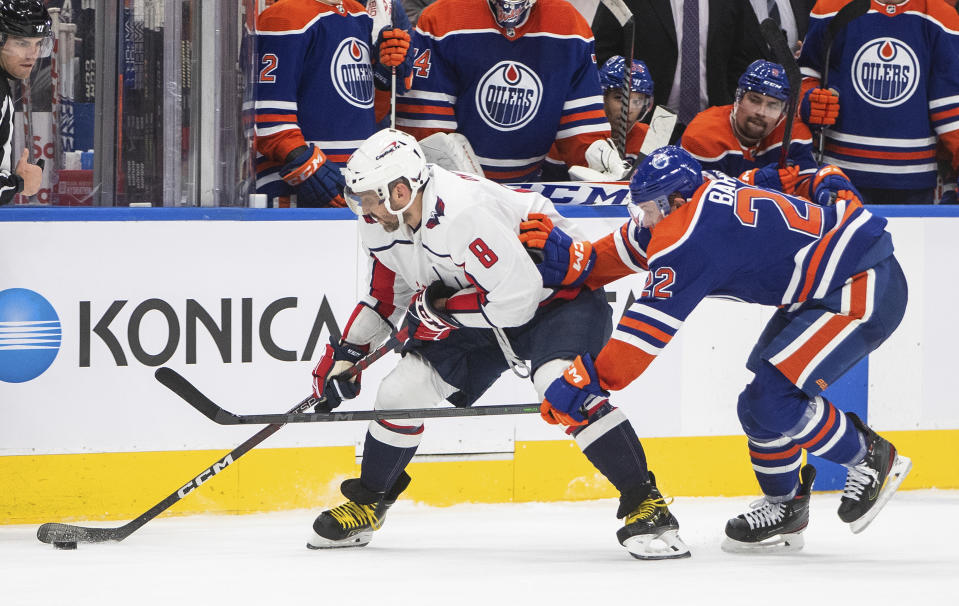 Washington Capitals' Alex Ovechkin (8) and Edmonton Oilers' Tyson Barrie (22) battle for the puck during the third period of an NHL hockey game in Edmonton, Alberta, Monday, Dec. 5, 2022. (Jason Franson/The Canadian Press via AP)