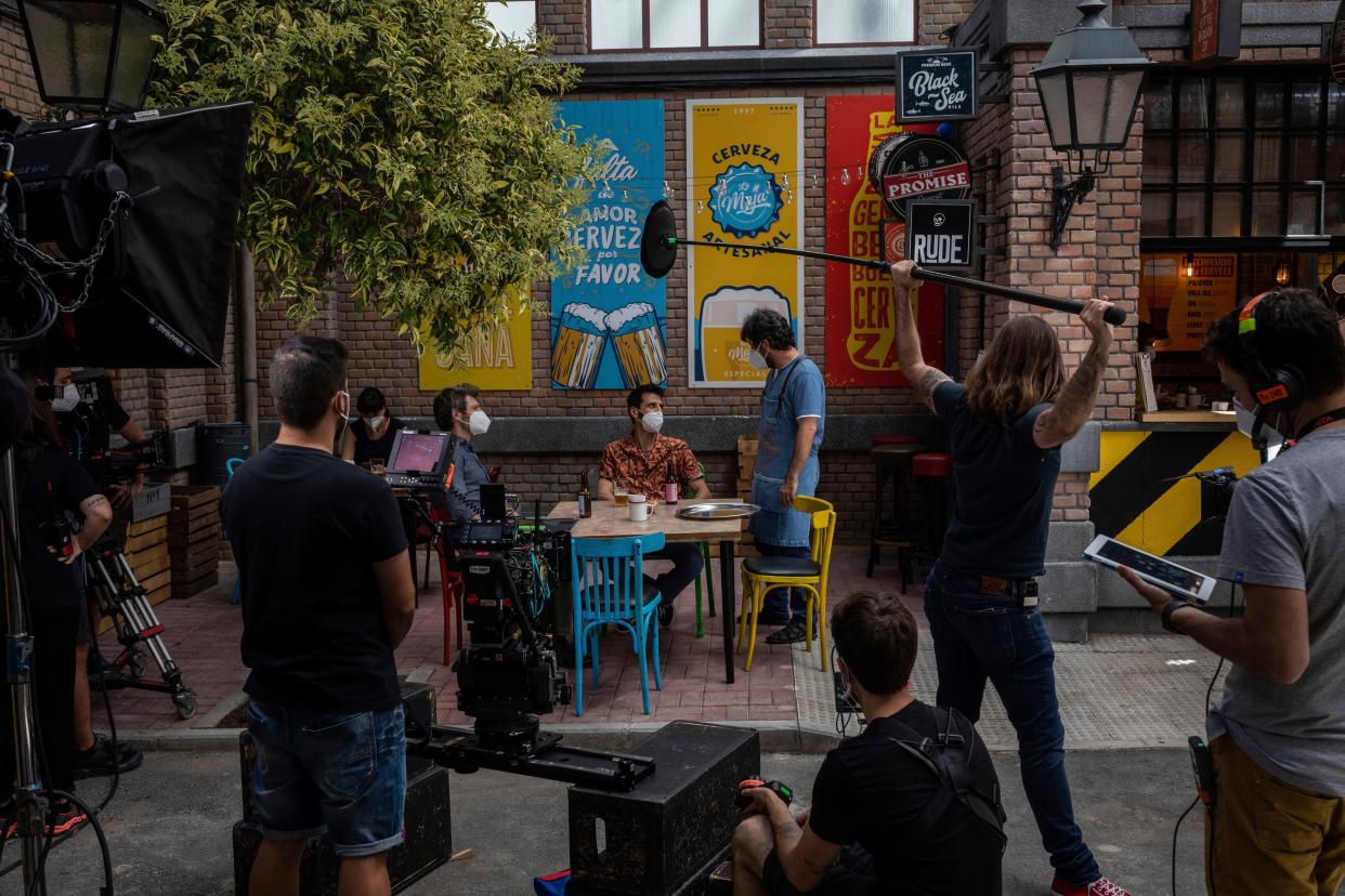 In this Thursday, June 18, 2020, photo, a technical staff and actors, wearing face masks to help curb the spread of the new coronavirus, rehearse at the "Central Market" soap-opera studio set in Boadilla del Monte, outskirts of Madrid, Spain. Spain's audiovisual sector is coming back to life after the dire months of lockdown as a consequence of the country's COVID-19 outbreak and subsequent state of emergency. On the set of the popular "Central Market" soap-opera, run on public broadcaster TVE, the technical staff and actors are back to work following of strict anti-COVID guidelines.