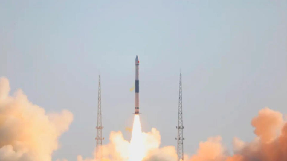 a black and white rocket launches into a blue sky.