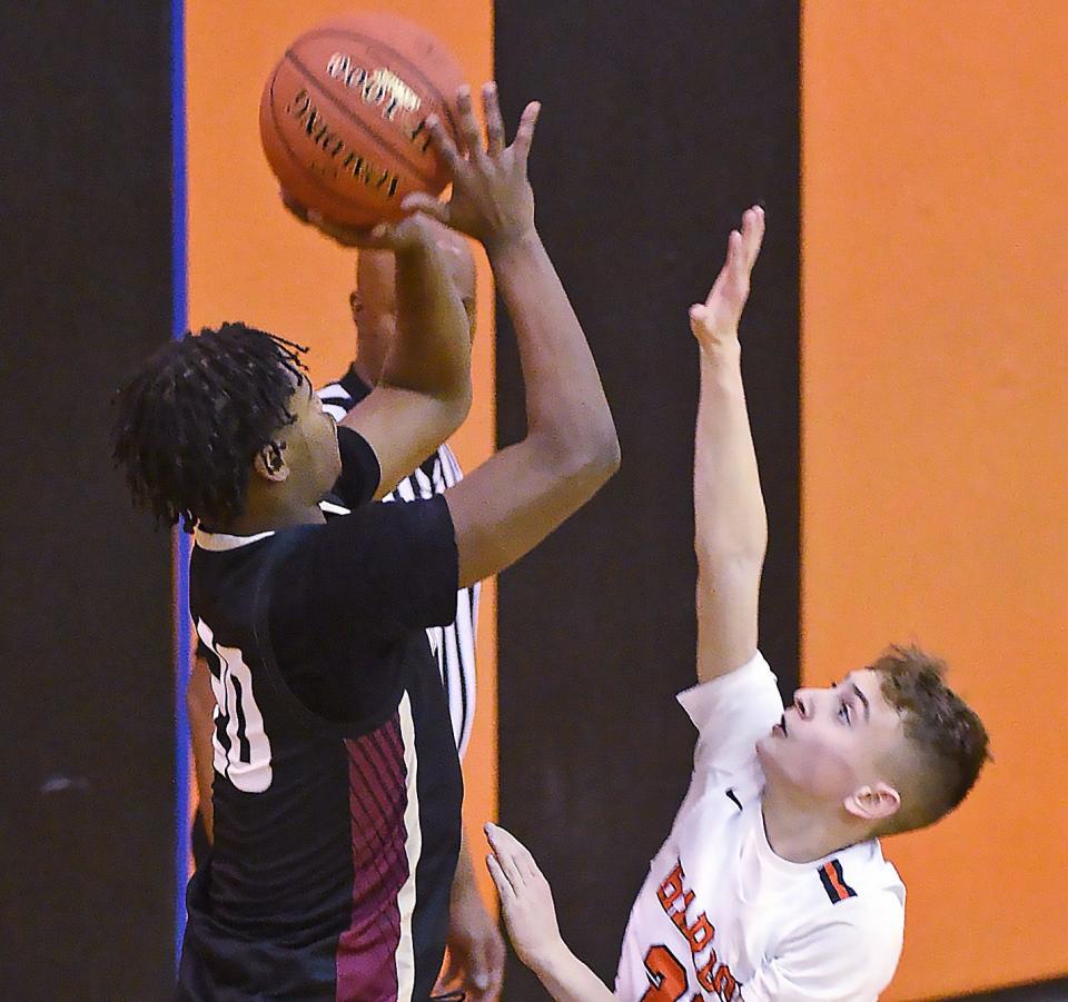 North East's Demetris Crosby, left, shoots over Harbor Creek's JT Delsandro in Harborcreek Township on Dec. 16. The Grapepickers play in Iroquois' Barringer Tournament this week, while the Huskies host a four-team tournament Wednesday and Thursday.