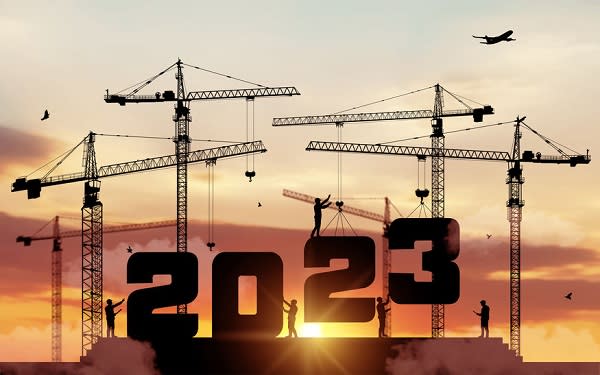 Silhouette staff works as a to prepare to welcome the new year 2023. Large construction site, many construction cranes set numbers 2023. Construction team sets numbers for New Year 2023. Vector.