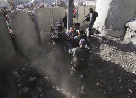 Israeli border policemen detain a Palestinian during clashes between Israeli troops and Palestinians, at Qalandiya checkpoint near the West Bank city of Ramallah, July 3, 2015. REUTERS/Mohamad Torokman