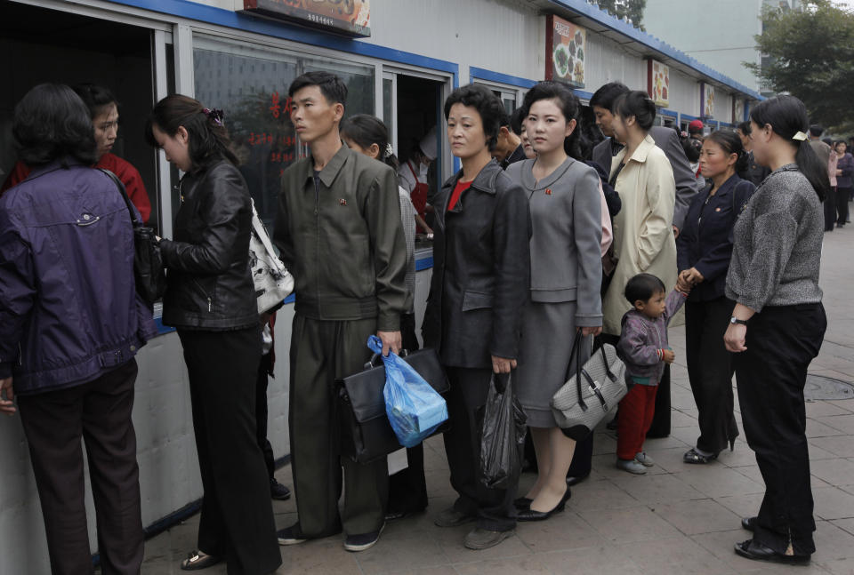 FILE- In this Oct. 11, 2010, file photo, residents queue up at a store to buy food in Pyongyang, North Korea. The coronavirus pandemic appears to be taking a heavy toll on North Korea, forcing its leader Kim Jong Un to sharply shrink his public activities and his people to go on panic buying of daily necessities, South Korea's spy agency told lawmaker Wednesday, May 6, 2020. (AP Photo/Vincent Yu, File)