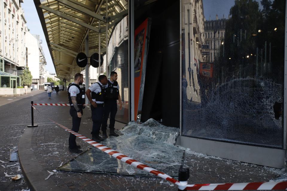 Police officers look at a damaged window of a store at 'Forum des Halles' in Paris on June 30, 2023, after protests following the shooting of a teenage driver by French police in the Paris suburb of Nanterre on June 27. French President Emmanuel Macron was scheduled to chair a new crisis meeting of ministers after a third straight night of nationwide protests over the deadly police shooting of a teenager saw cars torched, shops ransacked and hundreds arrested. (Photo by AFP) (Photo by -/AFP via Getty Images)