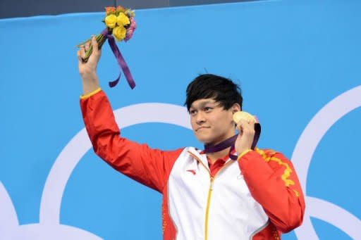 China's Sun Yang poses on the podium with his gold medal after winning the men's 400m freestyle swimming event at the London 2012 Olympic Games