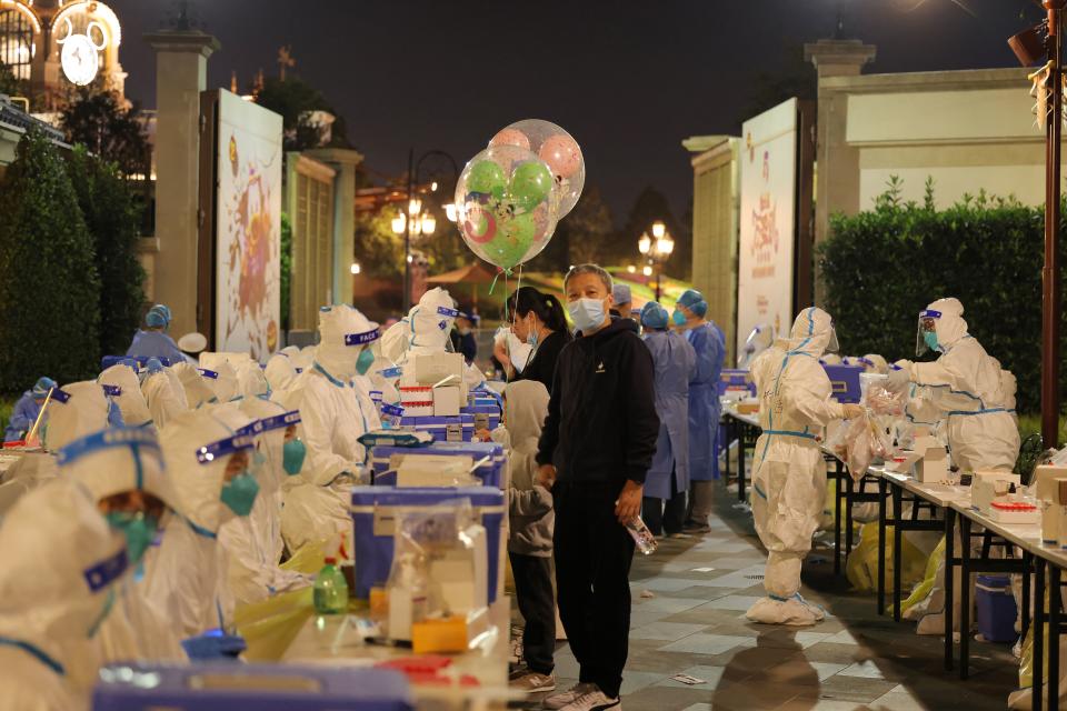 This photo taken on October 31, 2021 shows medical personnel testing visitors for the Covid-19 coronavirus at Disneyland in Shanghai after a single coronavirus case was detected at the park on the weekend. - China OUT (Photo by AFP) / China OUT (Photo by -/AFP via Getty Images)