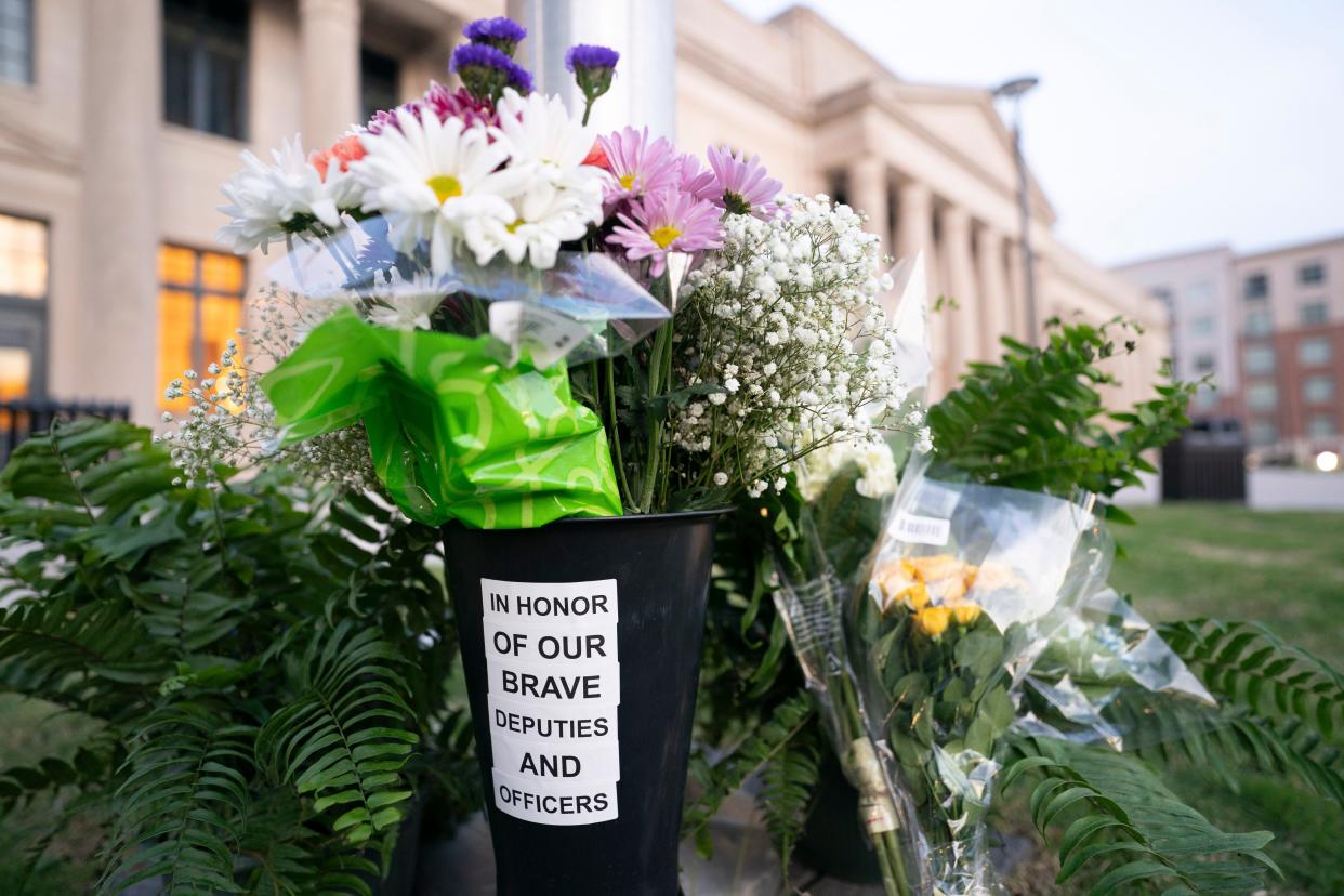 Flowers in memory of fallen law enforcement officers accumulate at the base of a flag pole outside the Federal Courthouse on April 30, 2024 in Charlotte, North Carolina. Four members of law enforcement were shot and killed the previous day while serving a warrant at a residence in Charlotte.