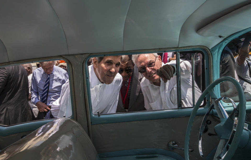 ARCHIVO - En esta foto de archivo del 14 de agosto de 2015, el historiador de La Habana, Eusebio Leal Spengler, a la derecha, señala algo al entonces secretario de Estado estadounidense, John Kerry, mientras miran dentro de un auto clasico estacionado en la Vieja Habana, Cuba. Leal falleció en la isla, según anunciaron el viernes 31 de julio de 2020 medios oficiales cubanos. (AP Foto/Ramón Espinosa, Archivo)