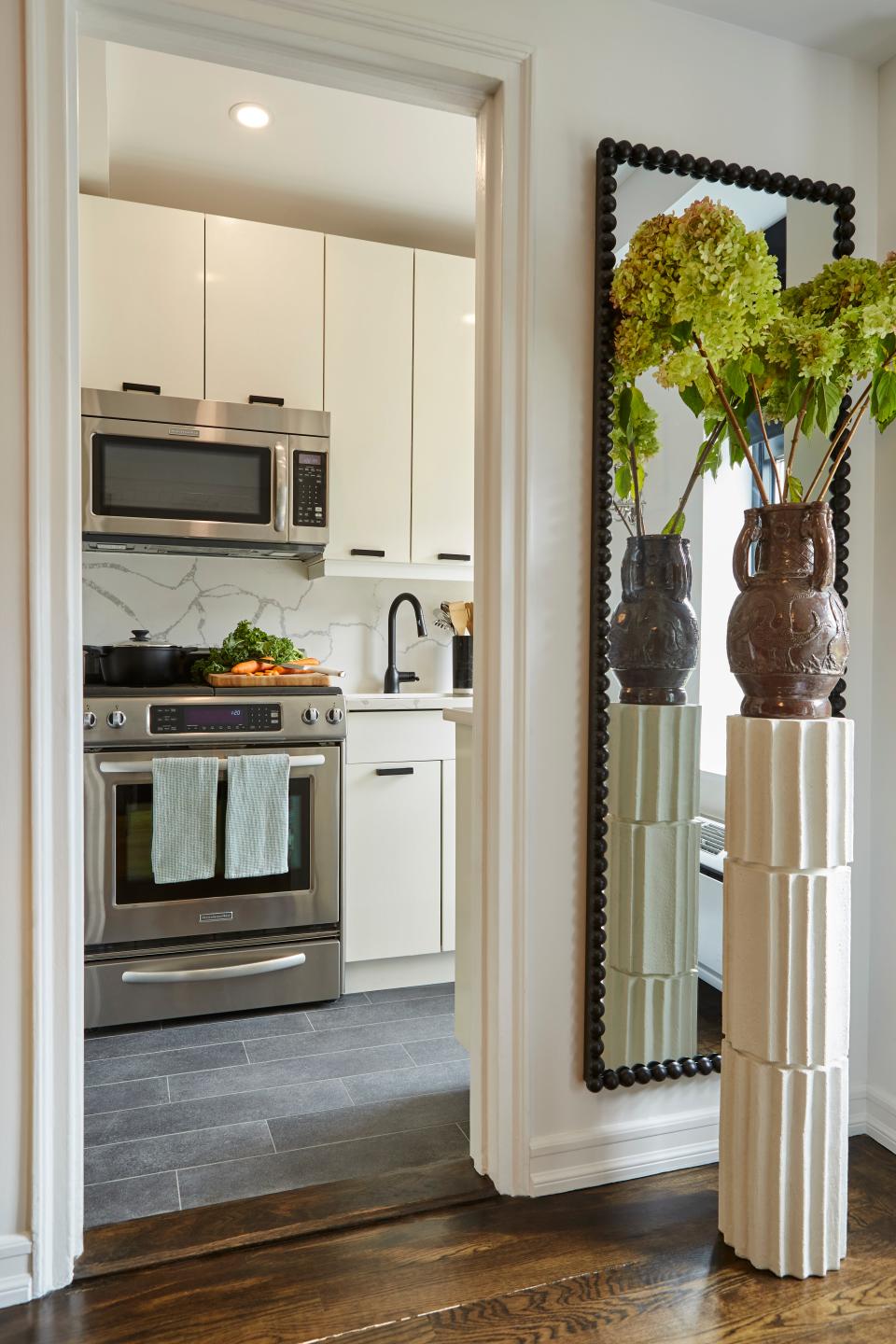 Near the kitchen entryway, Chris curated an elegant vignette with an Athena Calderone for Crate & Barrel pedestal, a vintage urn, and a bubble mirror from Wayfair.