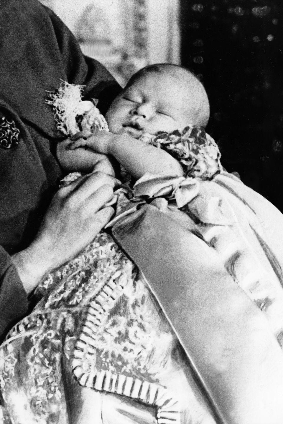 <p>A sleeping Charles is held by his mom, Queen Elizabeth II, at just one month old. The Prince was born on November 14, 1948 at Buckingham Palace.</p>