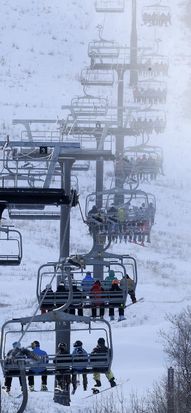 FILE - This Nov. 23, 2013, file photo, shows skiers and snowboarders on a lift at Park City Mountain Resort, in Park City, Utah. A coalition of Utah ski resort managers from Alta Ski Area, Brighton Resort, Canyons Resort, Deer Valley Resort, Park City Mountain Resort, Snowbird Ski and Summer Resort and Solitude Mountain Resort are reviving their plans for a series of interconnected chairlifts that would link seven ski areas that would give the state a Euro-style experience, they announced during a news conference Wednesday, March 19, 2014. (AP Photo/Rick Bowmer, File)