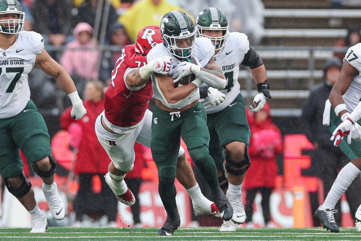 Michigan State Spartans running back Jalen Berger carries the ball during the first half as Rutgers Scarlet Knights defensive lineman Aaron Lewis tackles at SHI Stadium on October 14, 2023 in Piscataway, New Jersey.