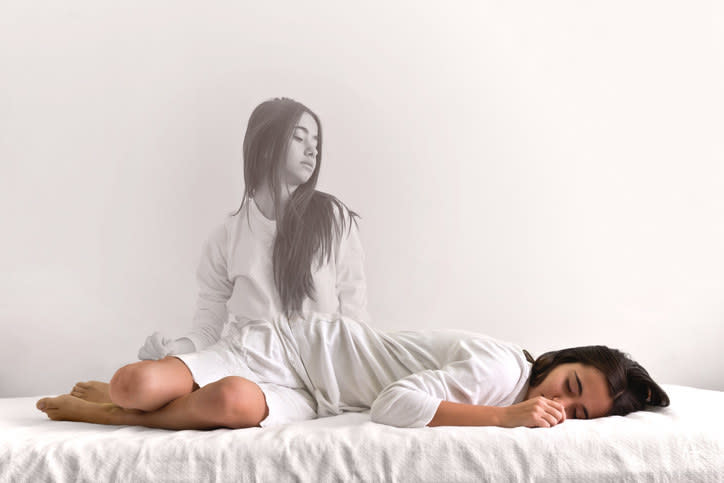 A woman's spirit appears removed from her body, as she watches herself sleep