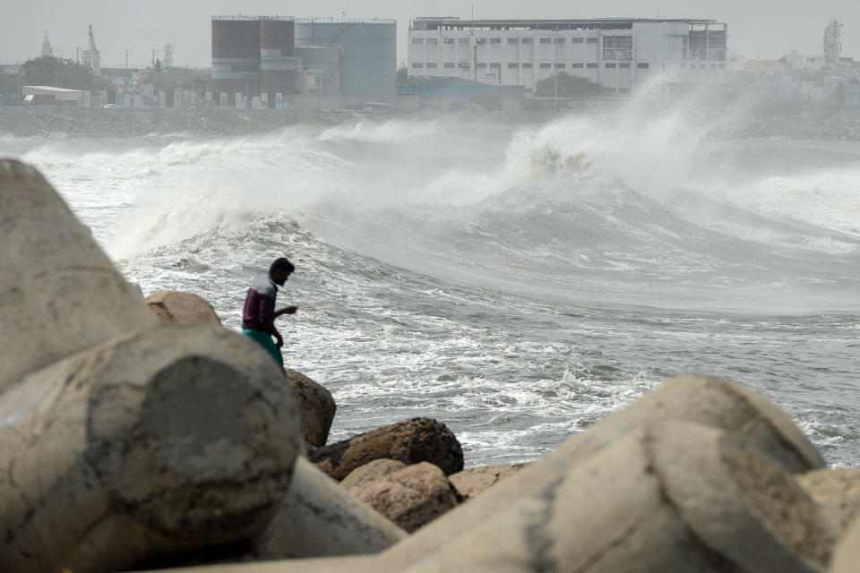 Image: A man looks out as waves hit a breakwater at Kasimedu fishing harbour in Chennai (Arun Sankar / AFP - Getty Images)