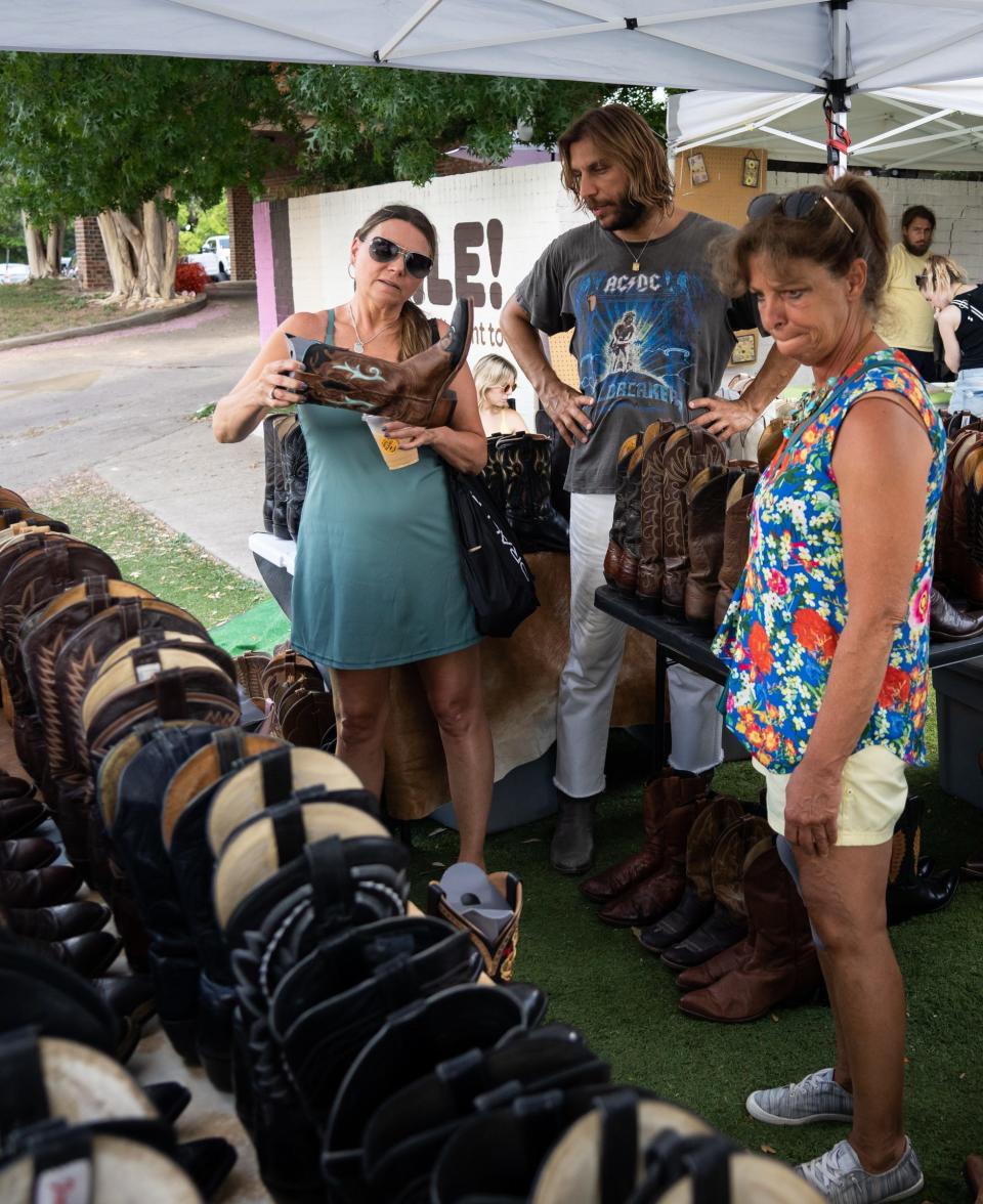 Joey Medina, center, helps Michelle Campbell, left, and Michelle Petruzziello, from Boston, find a new pair of boots at his South Congress Pop-Up shop, July 1, 2023. Medina says Bruce Springsteen once dropped by the pop-up. "He was blown away," said Medina, "his exact words were 'you're still finding this stuff?' And I said 'I guess man, we're trying!'"