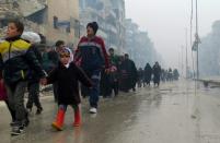 Syrian residents, fleeing violence in the restive Bustan al-Qasr neighbourhood, arrive in Aleppo's Fardos neighbourhood on December 13, 2016