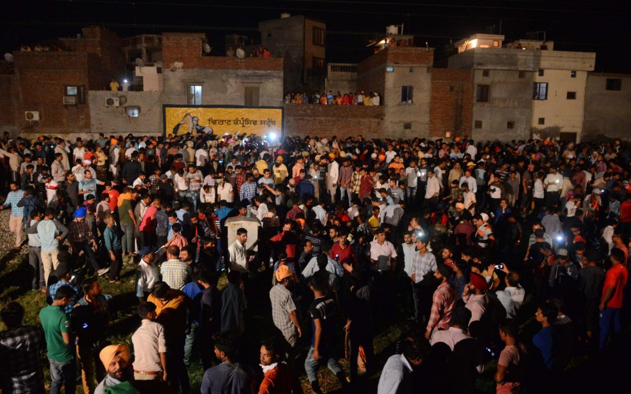 Indian relatives and revellers gather around the bodies of the victims of a train accident during the Hindu festival of Dussehra in Amritsar  - AFP