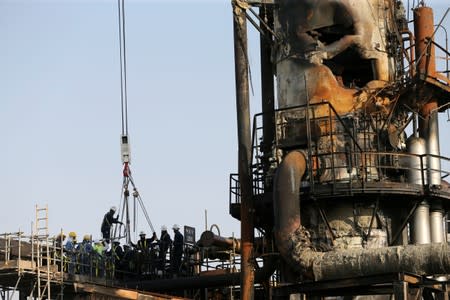 FILE PHOTO: Workers are seen at the damaged site of Saudi Aramco oil facility in Abqaiq