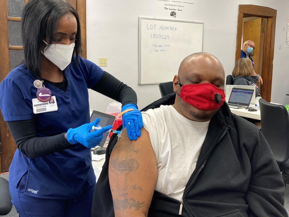 Larissa Hughes, a medical assistant with Community Health Network, delivers a dose of the Johnson & Johnson COVID-19 vaccine to Jermaine Evans at a vaccination clinic at the Martin Center for sickle cell disease patients and their family members.