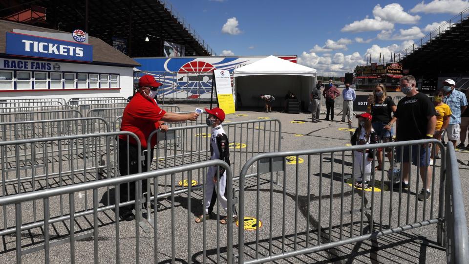 A young fan has his temperature checked during a walkthrough at the New Hampshire Motor Speedway Friday, July 31, 2020, in Loudon, N.H., in preparation for this Sunday's Foxwoods 301 NASCAR auto race. (AP Photo/Charles Krupa)