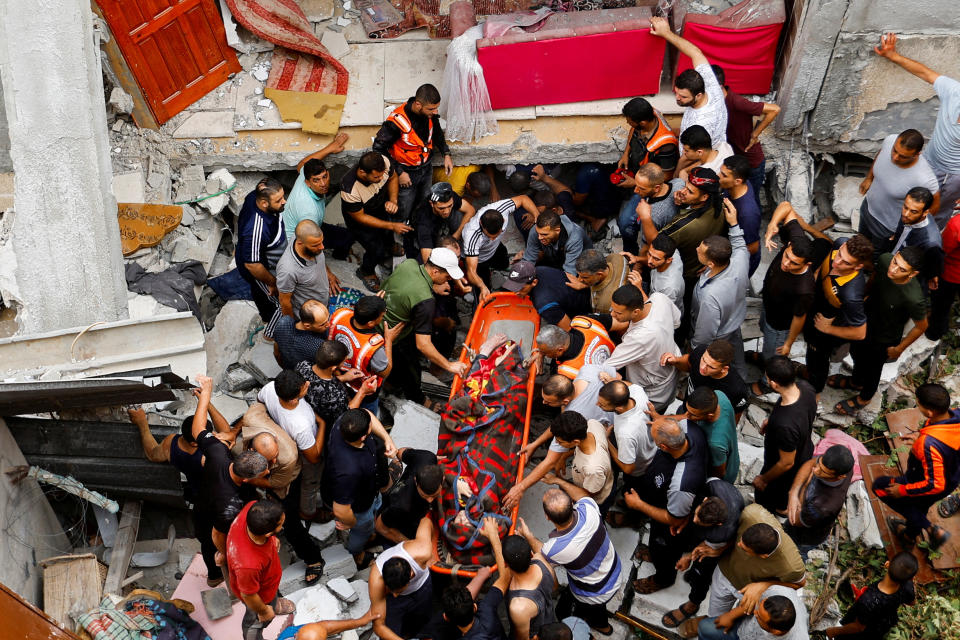 A body is removed from the rubble in the southern Gaza Strip on Monday. (Ibraheem Abu Mustafa/Reuters)