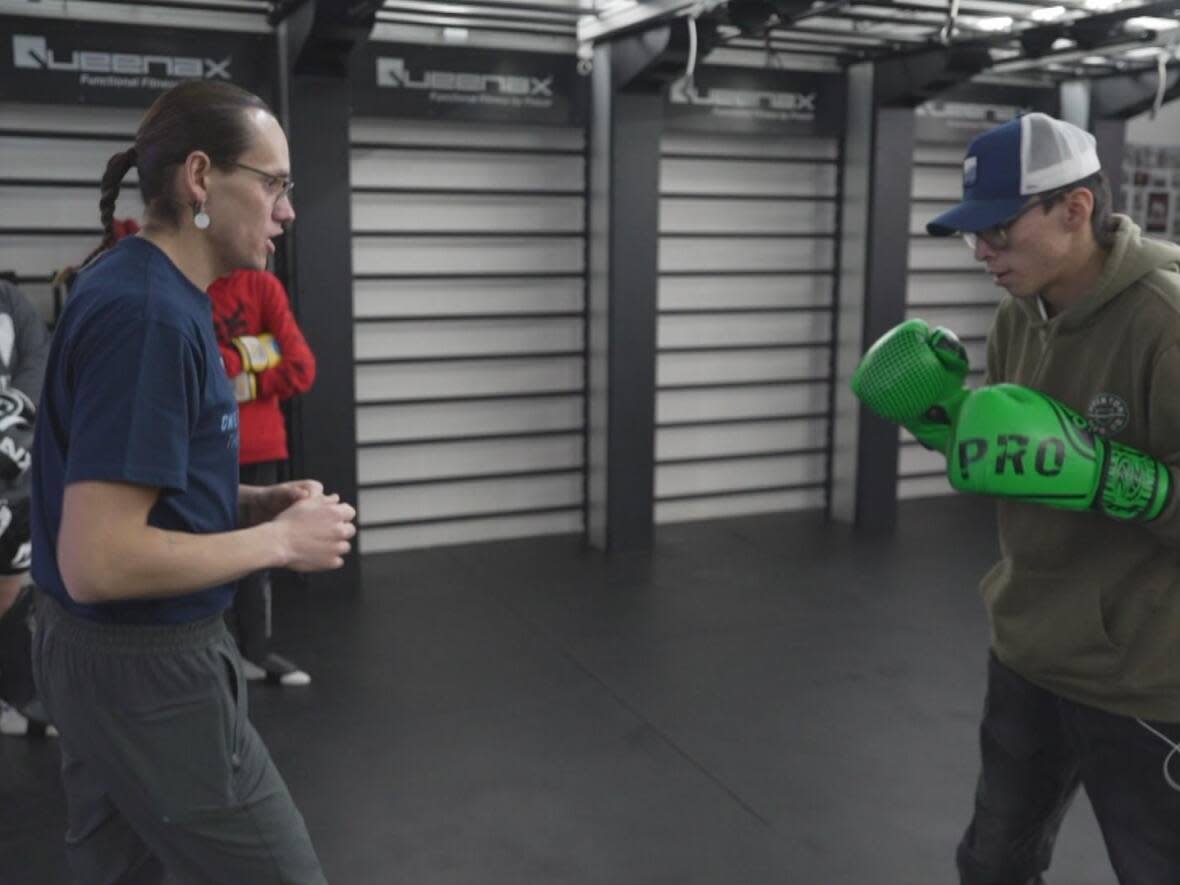 Tawny Big Bull, left, demonstrates a kickboxing drill to students. (David Mercer/CBC - image credit)