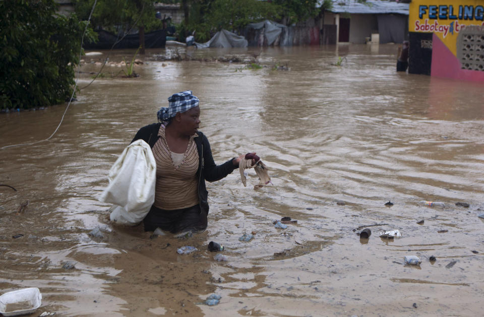 A woman wades through a flooded street triggered by Tropical Storm Isaac in Port-au-Prince, Haiti, Saturday, Aug. 25, 2012. Tropical Storm Isaac swept across Haiti's southern peninsula early Saturday, dousing a capital city prone to flooding and adding to the misery of a poor nation still trying to recover from the 2010 earthquake. (AP Photo/Dieu Nalio Chery)
