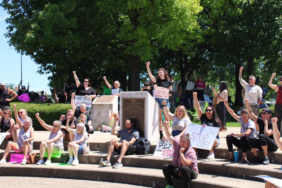 Protesters raise their fists in support of reproductive rights during a demonstration Saturday, July 9, 2022, at the Sojourner Truth Monument in Battle Creek, Michigan.