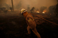 <p>A firefighter works to put out a forest fire in the village of Carvoeiro, near Castelo Branco, Portugal, July 25, 2017. (Rafael Marchante/Reuters) </p>