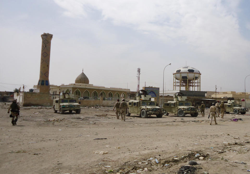 In this photo released by the Iraqi Army taken on March 20, 2014, Iraqi Security forces deploy in front of a damaged mosque after clashes with al-Qaida fighters in Ramadi, 70 miles (115 kilometers) west of Baghdad, Iraq. Iraqi military officials are warning that efforts to clear militants from Fallujah and parts of nearby Ramadi are proving much more difficult than they anticipated when the jihadists showed up three months ago. That realization, as they acknowledged during a recent tour of special forces operations, casts doubt on Iraq's ability to hold elections in Fallujah next month. (AP Photo/Iraqi Army)