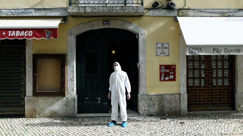 Un hombre con traje de protección en una calle en Lisboa.