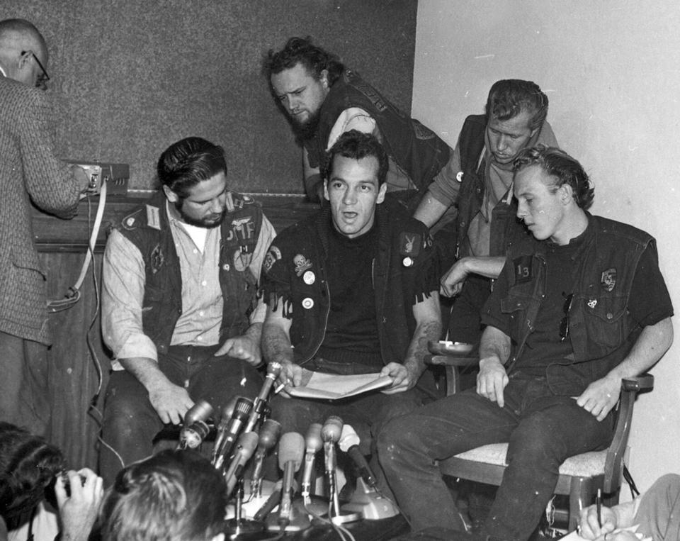 Ralph "Sonny" Barger, president of the Oakland chapter of the Hell's Angels, reads a statement during a news conference in Oakland, Ca., Nov. 19, 1965. Barger announced they will not show up for the Vietnam Day Committee's march on the Oakland Army Terminal, Saturday. The members of the Oakland Hell's Angels chapter from left are, Cliff Workman, treasurer; Barger; Tiny Walter, sergeant at arms; Ron Jacobson, secretary; and Tom Thomas, vice president, seated far right.