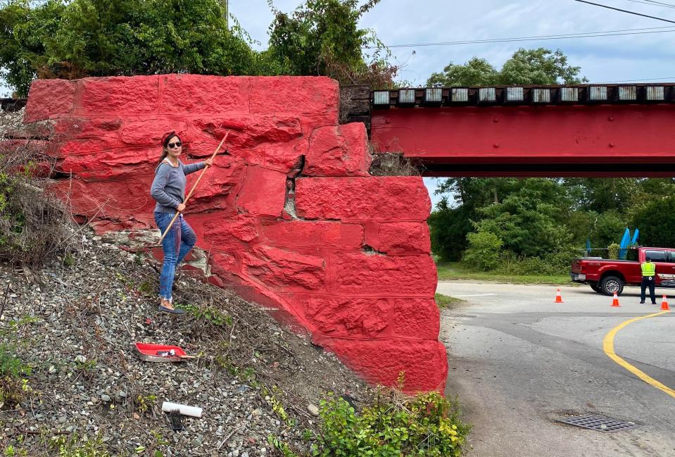 Karyn Jimenez-Elliott paints the entrance to Common Fence Point in Portsmouth on Sunday, Sept. 25, 2022.