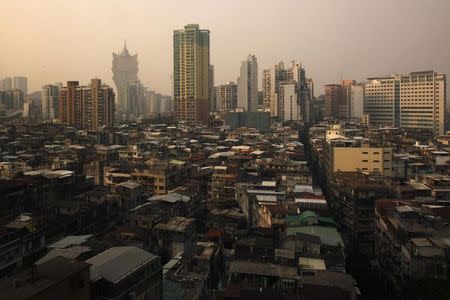 Old blocks are seen at a residential district as the Grand Lisboa casino (L) is seen in the background in Macau in this October 11, 2012 file photo. REUTERS/Bobby Yip