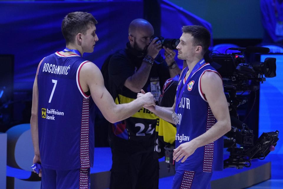 Serbia guard Bogdan Bogdanovic (7) and Serbia guard Aleksa Avramovic (30) greet each other with their silver medals after losing to Germany in the championship game of the Basketball World Cup in Manila, Philippines, Sunday, Sept. 10, 2023. (AP Photo/Michael Conroy)