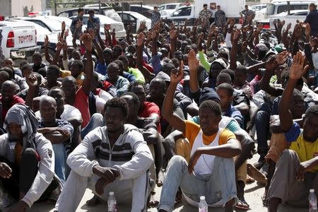 Illegal migrants sit at a temporary detention centre after they were detained by Libyan authorities in Tripoli, Libya October 8, 2015 . REUTERS/Ismail Zitouny