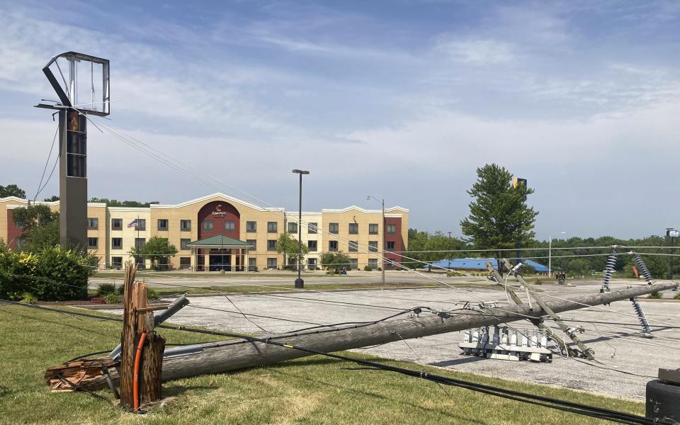 A utility pole lies in a parking lot on Friday, June 30, 2023, snapped off in derecho winds that hit Springfield, Ill., a day earlier along with a string of others on an east-side commercial strip just west of Interstate 55. (AP Photo/John O'Connor)