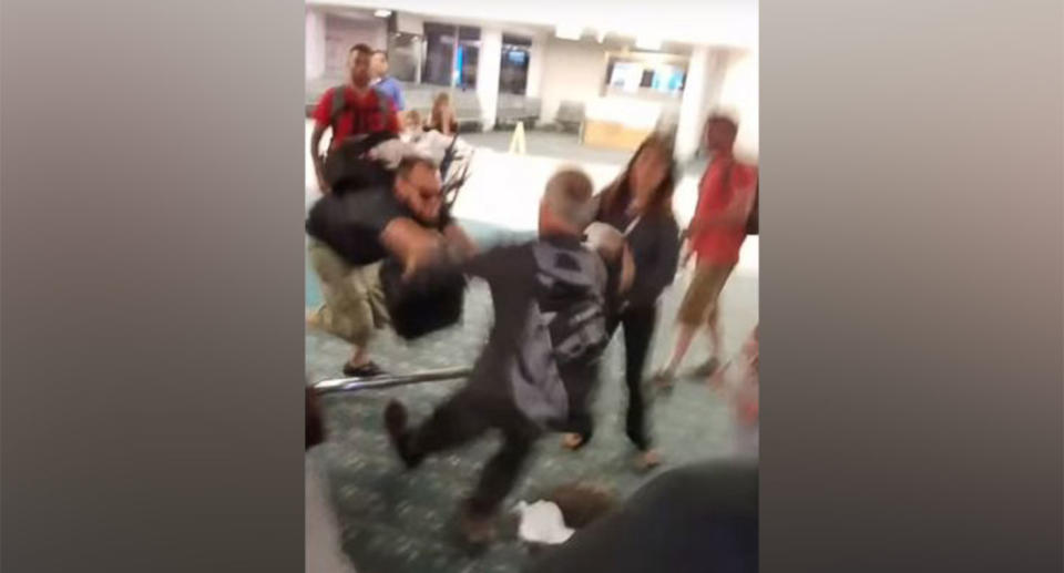 After disembarking the aircraft, Matthew Silvay pushes the other passenger, in full view of onlookers including children. Source: Joshua Manley / You Tube